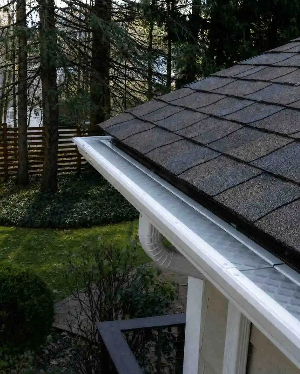 Gutter guard fitted over a residential rain gutter to reduce debris